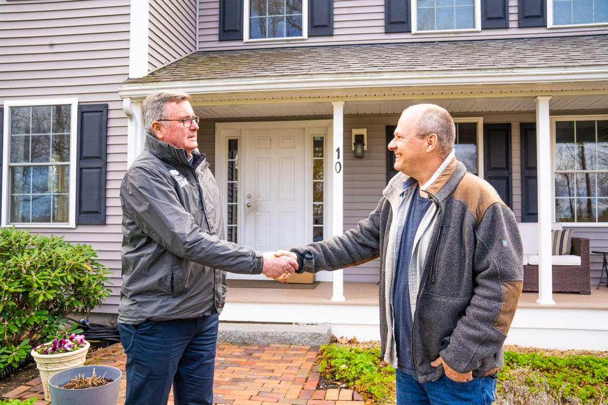tree care expert and homeowner shake hands