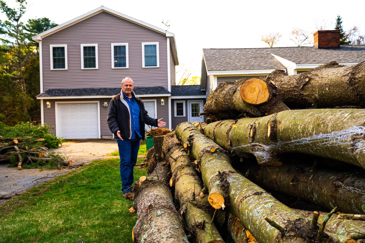 homeowner standing near pile of logs and brush