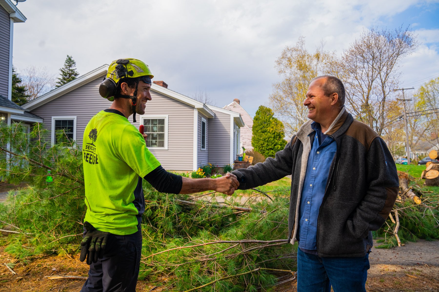 tree service crew leader with happy customer