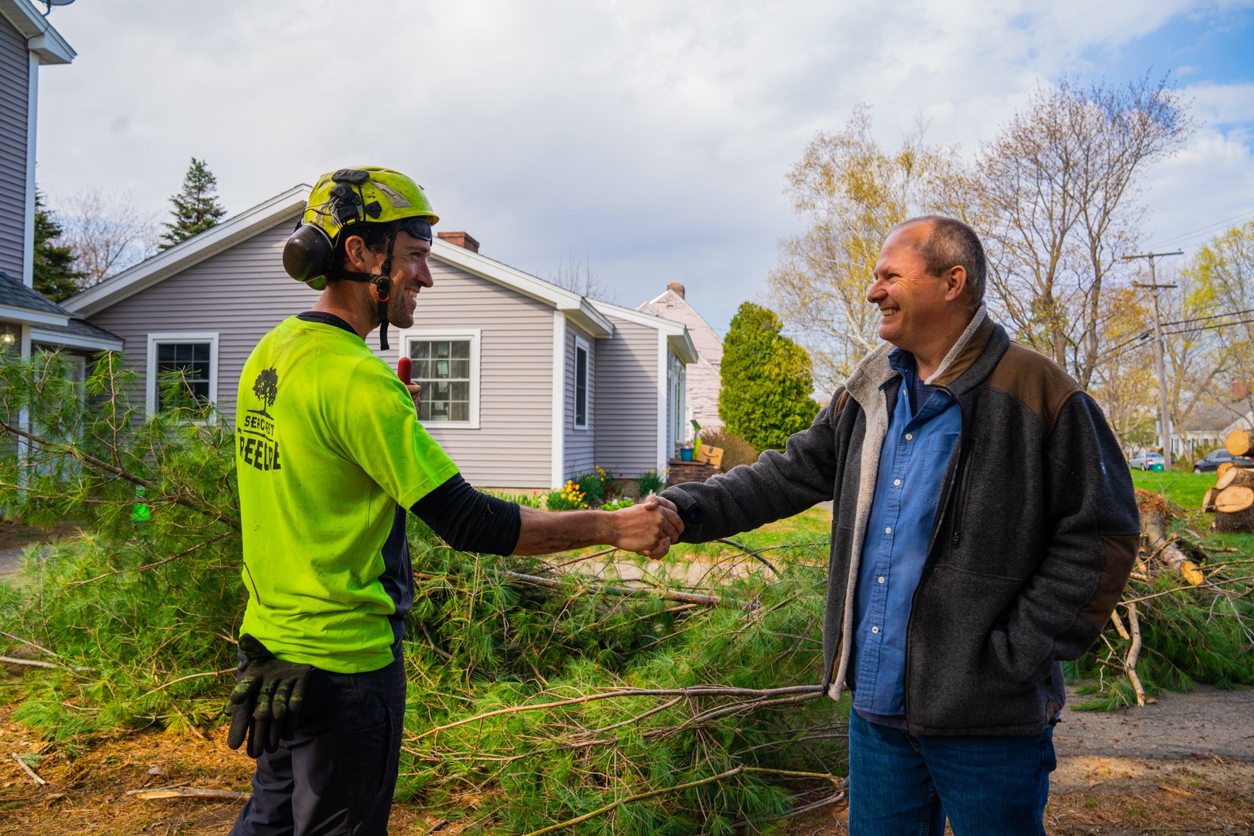 tree service crew leader shakes hands with homeowner
